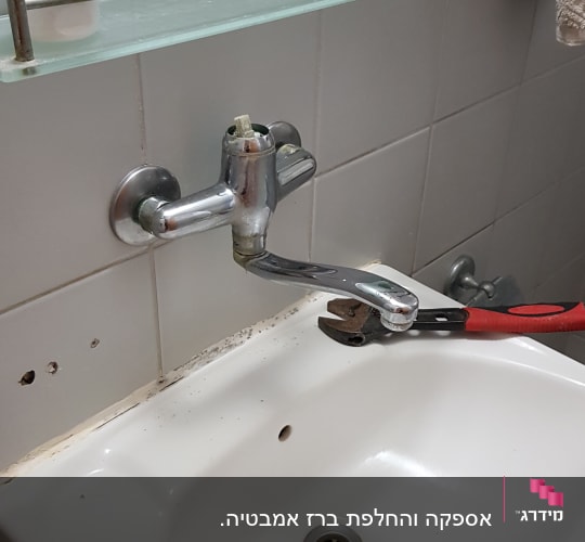 ברז כיור עם מפתח צינורות לתיקון